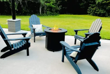 Four Adirondack chairs around a black firepit.