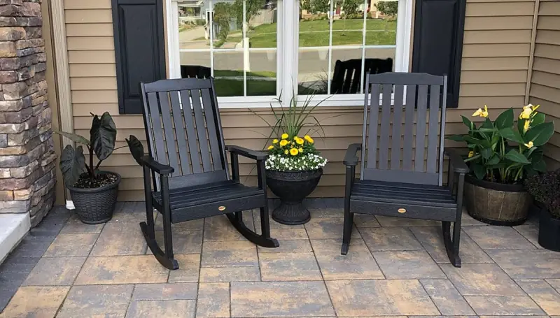 Two brown rocking chairs on a tiled patio.